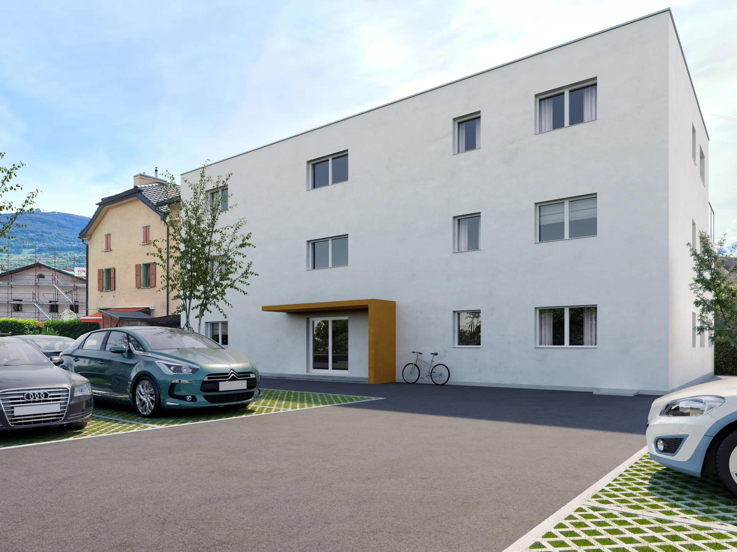 La résidence La Grotte, volume blanc à toit plat et auvent d'entrée en bois, vue depuis le parking
